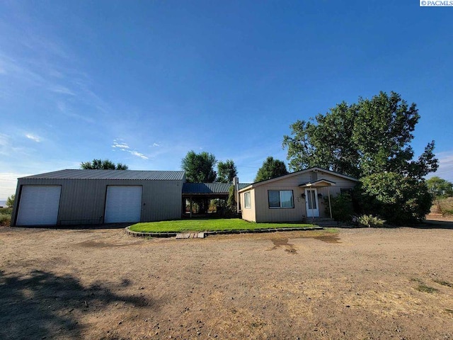 single story home with a garage, an outdoor structure, and a front yard