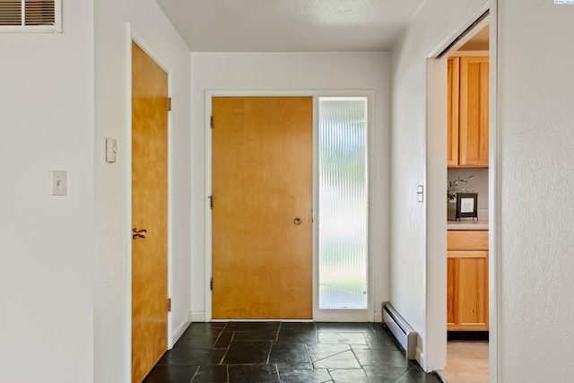 doorway to outside with a baseboard heating unit