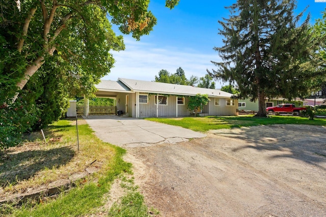 ranch-style house with a carport and a front lawn