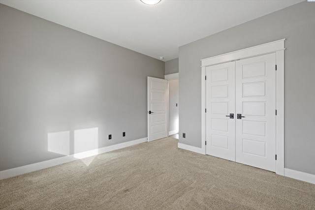 unfurnished bedroom featuring a closet, carpet flooring, and baseboards