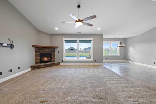 unfurnished living room featuring lofted ceiling, a fireplace, baseboards, and light colored carpet