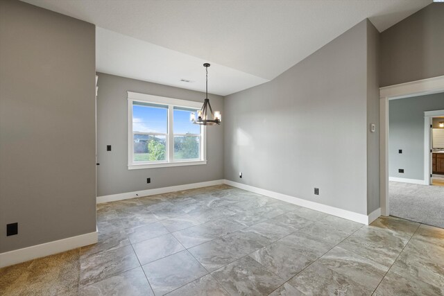 spare room with vaulted ceiling, a notable chandelier, and baseboards