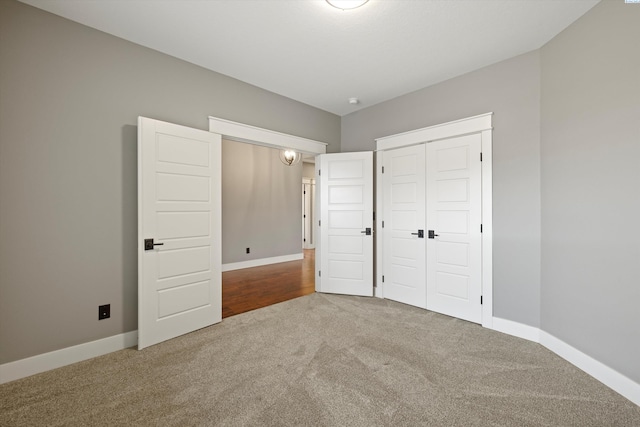 unfurnished bedroom with carpet, baseboards, and a closet