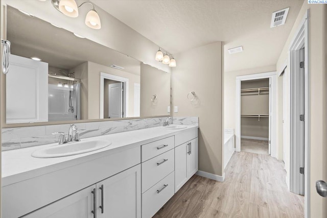 200 Ladera St, Prosser, WA 99350 - full bath featuring wood finished floors, a shower stall, double vanity, baseboards, and a spacious closet