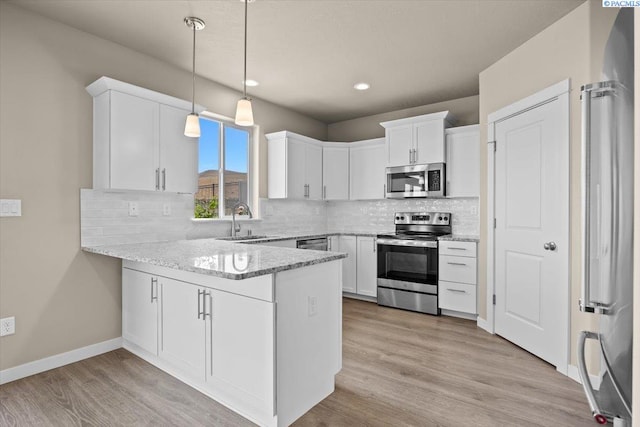 200 Ladera St, Prosser, WA 99350 - kitchen with appliances with stainless steel finishes, a sink, a peninsula, white cabinets, and tasteful backsplash