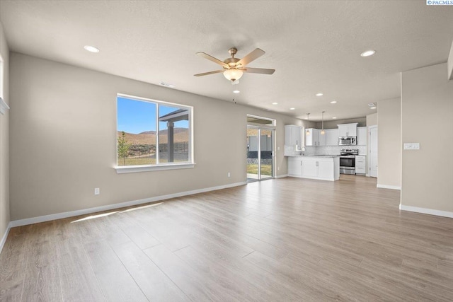 200 Ladera St, Prosser, WA 99350 - unfurnished living room with a ceiling fan, recessed lighting, baseboards, and light wood-style flooring