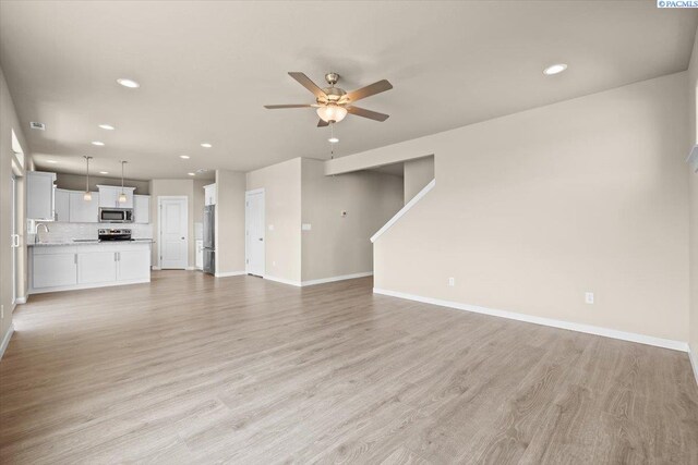 200 Ladera St, Prosser, WA 99350 - unfurnished living room with a ceiling fan, recessed lighting, baseboards, light wood finished floors, and a sink
