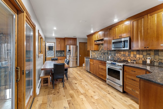 405 W 7th Ave, Ritzville, WA 99169 - kitchen with sink, light hardwood / wood-style flooring, appliances with stainless steel finishes, backsplash, and dark stone counters