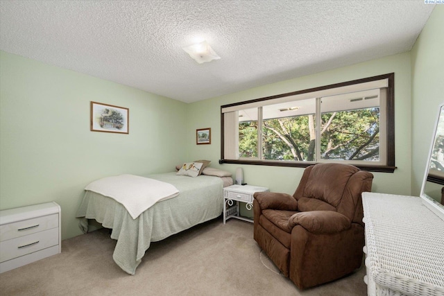 bedroom with light carpet and a textured ceiling