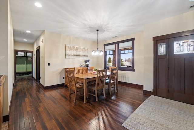 dining area with radiator heating unit, an inviting chandelier, and dark hardwood / wood-style flooring