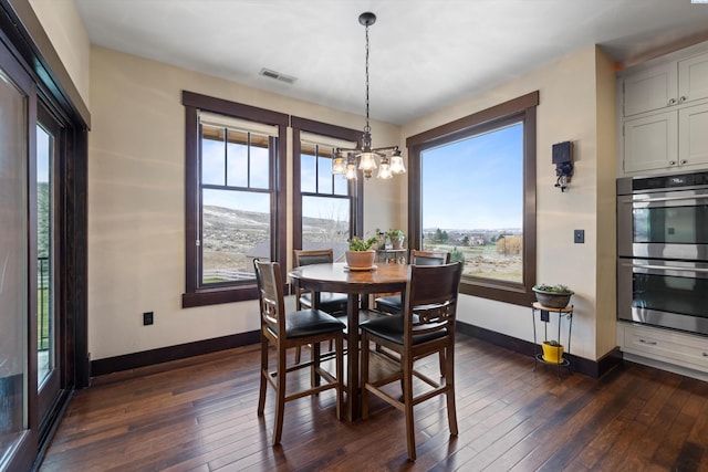 dining room with dark wood-type flooring and a chandelier