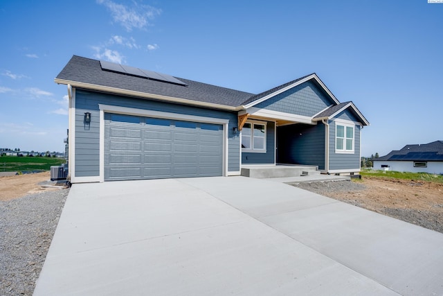 1060 SW Panorama Dr, Pullman, WA 99163 - view of front facade featuring a garage, cooling unit, roof mounted solar panels, a porch, and driveway