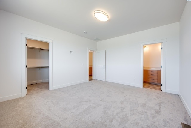 1060 SW Panorama Dr, Pullman, WA 99163 - unfurnished bedroom with baseboards, visible vents, a walk in closet, and light colored carpet