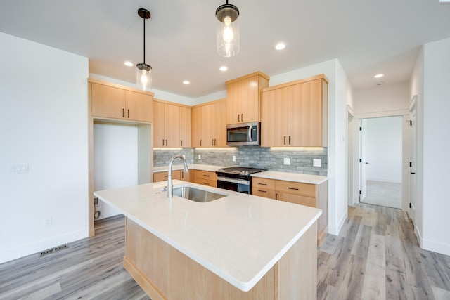 1060 SW Panorama Dr, Pullman, WA 99163 - kitchen featuring a sink, light wood-style floors, light brown cabinets, stainless steel appliances, and visible vents