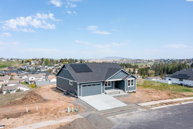 1060 SW Panorama Dr, Pullman, WA 99163 - view of front of home with roof with shingles, a residential view, a porch, roof mounted solar panels, and concrete driveway
