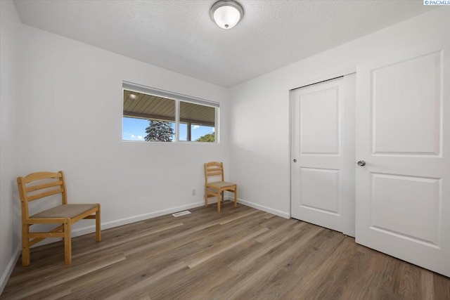 3925 W Okanogan Ave, Kennewick, WA 99336 - unfurnished bedroom with wood finished floors, baseboards, a closet, and a textured ceiling