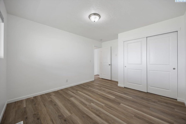 3925 W Okanogan Ave, Kennewick, WA 99336 - unfurnished bedroom with wood finished floors, baseboards, a closet, and a textured ceiling