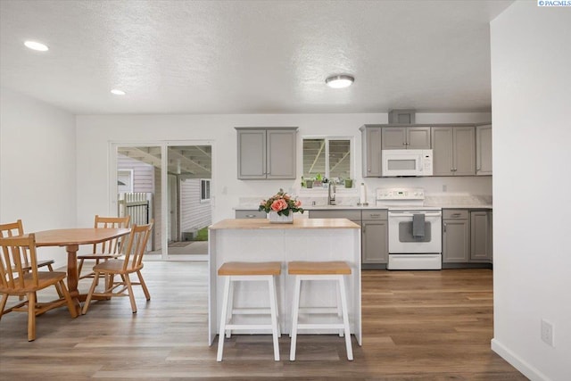 3925 W Okanogan Ave, Kennewick, WA 99336 - kitchen with white appliances, gray cabinetry, light countertops, wood finished floors, and a textured ceiling