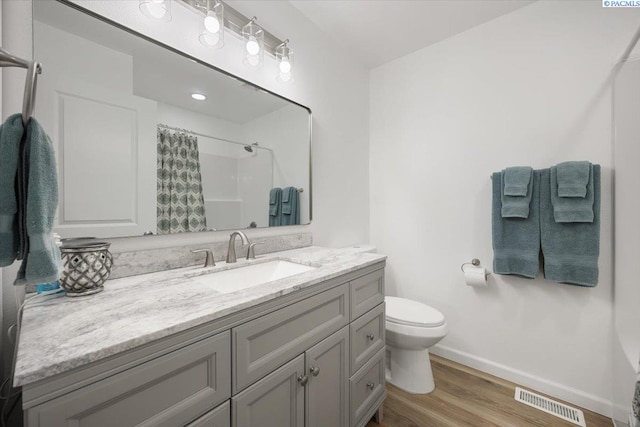 3925 W Okanogan Ave, Kennewick, WA 99336 - full bathroom featuring baseboards, toilet, vanity, wood finished floors, and a shower with curtain