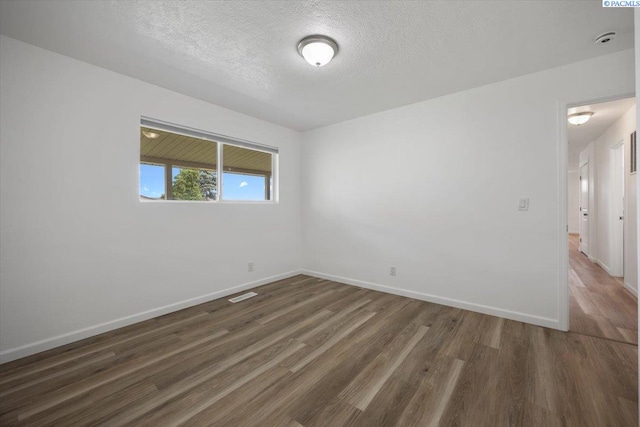 3925 W Okanogan Ave, Kennewick, WA 99336 - spare room featuring wood finished floors, a textured ceiling, and baseboards