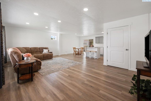 3925 W Okanogan Ave, Kennewick, WA 99336 - living room with light wood finished floors, recessed lighting, a textured ceiling, and baseboards