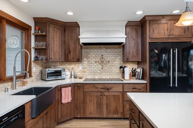 kitchen with a toaster, open shelves, light countertops, custom exhaust hood, and black appliances