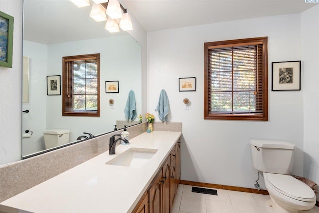 bathroom featuring visible vents, toilet, vanity, baseboards, and tile patterned floors