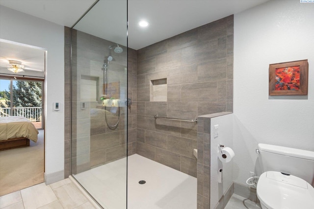 ensuite bathroom with tile patterned floors, toilet, ensuite bath, and a walk in shower