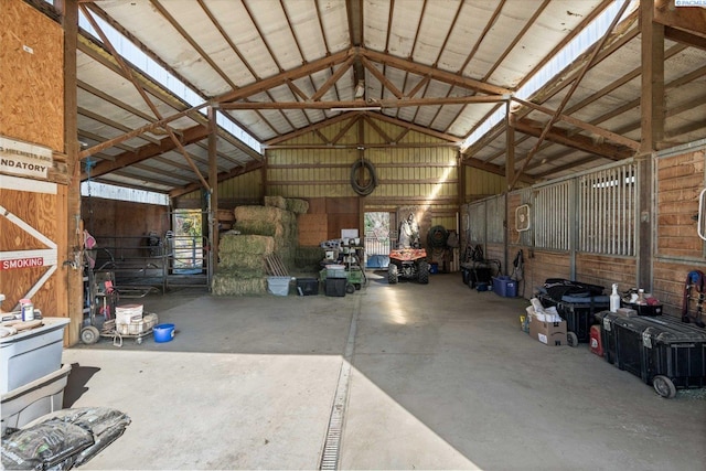 misc room with lofted ceiling, concrete floors, and metal wall