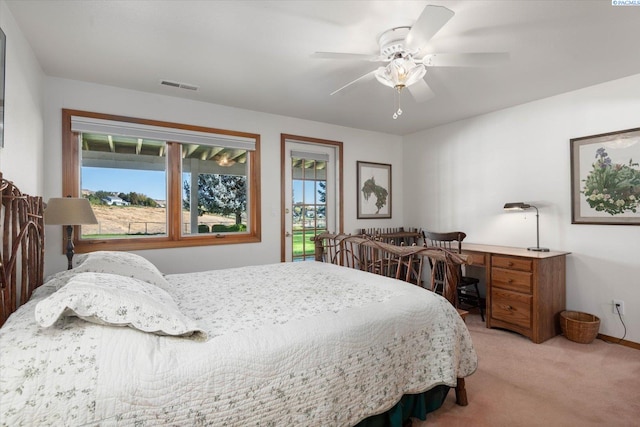 bedroom with a ceiling fan, light colored carpet, visible vents, and multiple windows