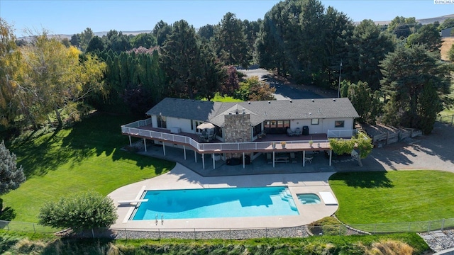 rear view of house featuring fence, a deck, a patio, and a yard