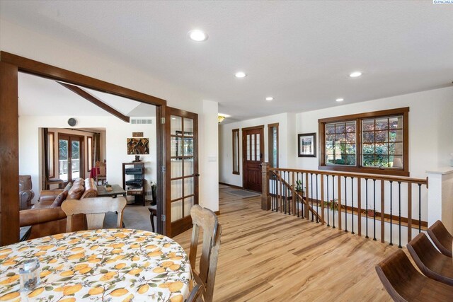 dining area with lofted ceiling, light wood finished floors, visible vents, and recessed lighting