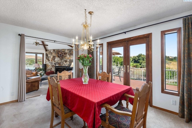 dining room with a textured ceiling, light carpet, a fireplace, baseboards, and french doors