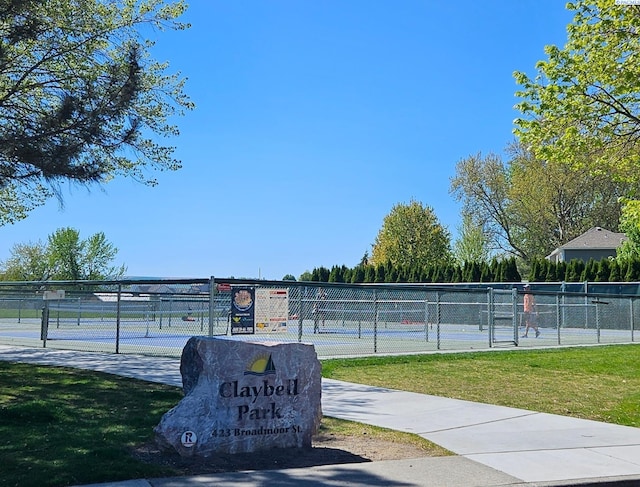 surrounding community with fence, a yard, and a tennis court