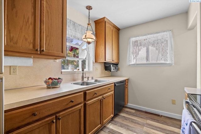 213 Bernard Ave, Richland, WA 99352 - kitchen with dishwashing machine, light wood-type flooring, brown cabinets, pendant lighting, and light countertops