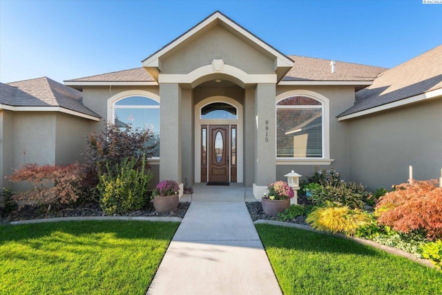 property entrance featuring a lawn