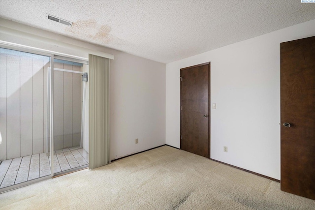 spare room featuring carpet and a textured ceiling