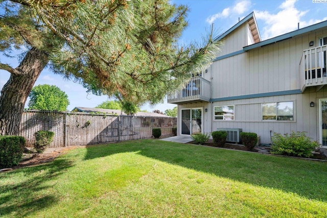 view of yard featuring a balcony and central AC unit