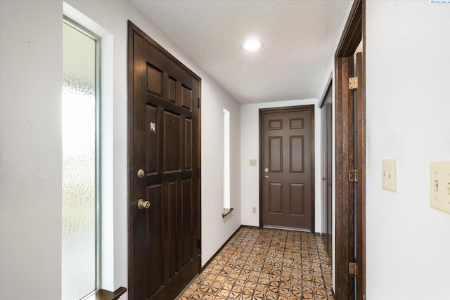 foyer entrance with a textured ceiling and light floors