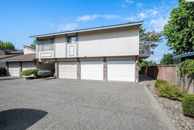view of front of property featuring a garage and stone siding