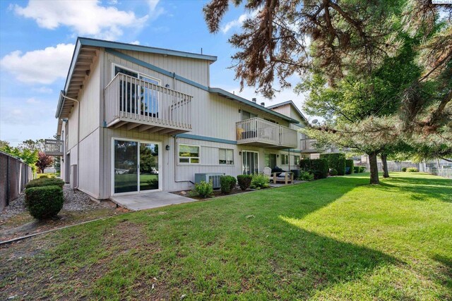 back of property featuring a balcony and central AC
