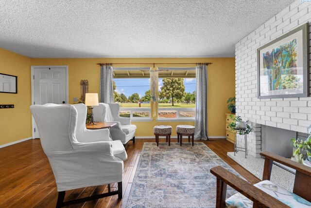 912 Rd 44, Pasco, WA 99301 - living room with a textured ceiling, wood finished floors, and a brick fireplace