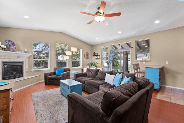 912 Rd 44, Pasco, WA 99301 - living area featuring plenty of natural light, ceiling fan, vaulted ceiling, a glass covered fireplace, and wood finished floors