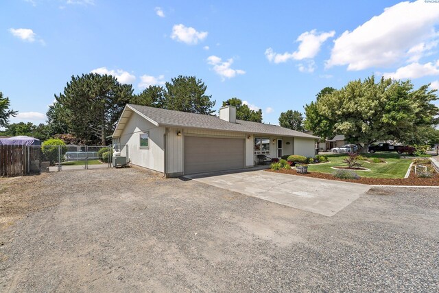 912 Rd 44, Pasco, WA 99301 - ranch-style house with concrete driveway, a chimney, an attached garage, and a gate