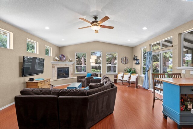 912 Rd 44, Pasco, WA 99301 - living room featuring wood finished floors, a glass covered fireplace, vaulted ceiling, ceiling fan, and a textured ceiling