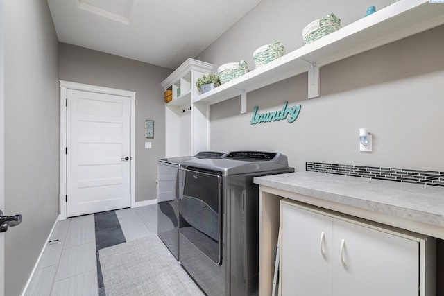 washroom with tile patterned flooring, laundry area, washer and clothes dryer, and baseboards