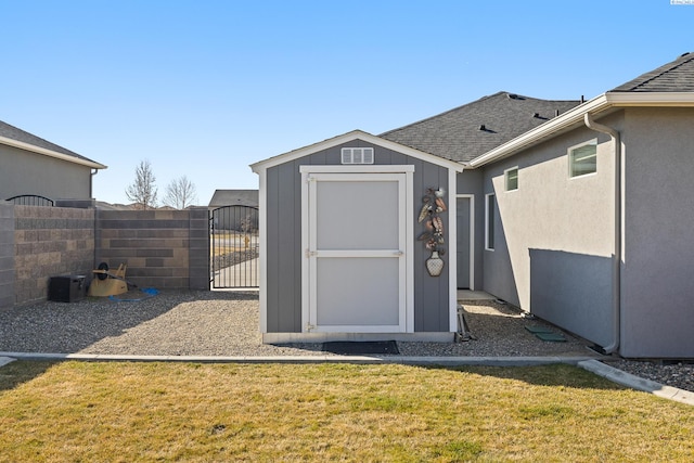 view of shed featuring fence and a gate