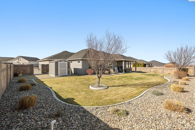 rear view of property with a fenced backyard, an outbuilding, a gate, a storage unit, and a patio area