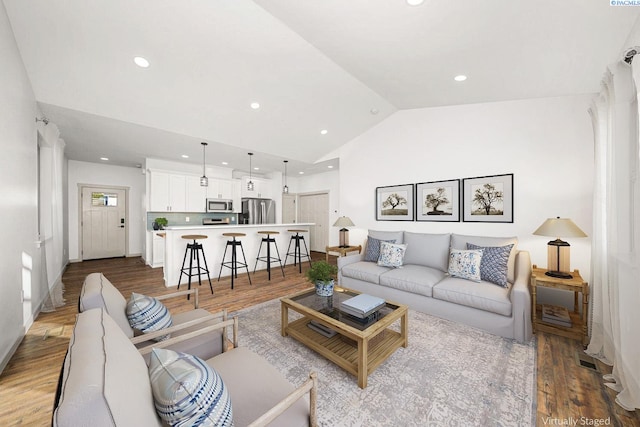 living room with vaulted ceiling and light wood-type flooring