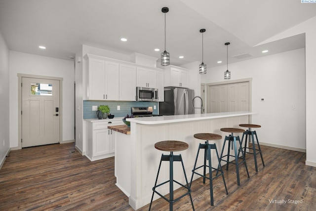 kitchen with a kitchen island with sink, white cabinetry, and stainless steel appliances